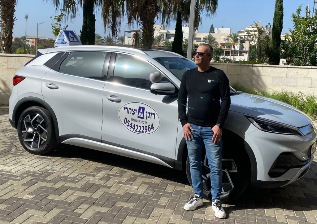 רונן יצהרי לצד רכב לימוד הנהיגה שלו